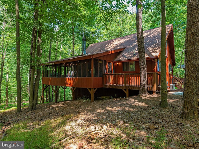 rear view of property featuring a wooden deck and a sunroom