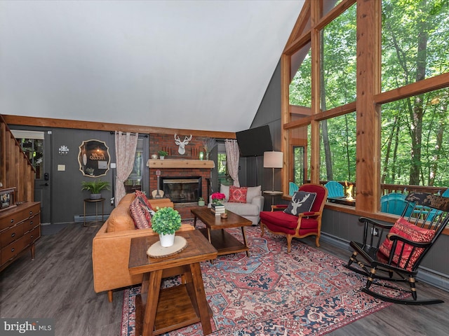 living room with dark hardwood / wood-style flooring, a brick fireplace, a baseboard radiator, and high vaulted ceiling