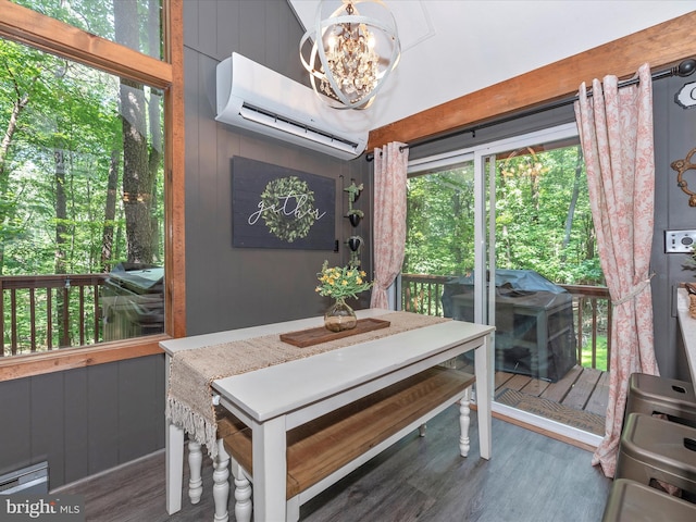 dining space with dark wood-type flooring, a wall mounted AC, a notable chandelier, and wood walls