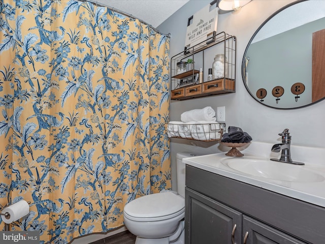 bathroom with a shower with curtain, vanity, toilet, and a textured ceiling