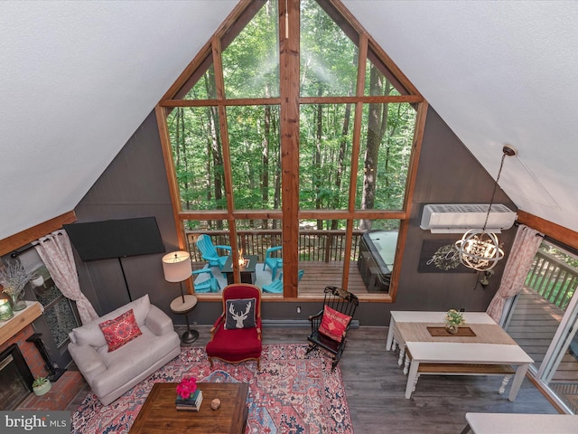 living room with an inviting chandelier, lofted ceiling, wood-type flooring, and an AC wall unit