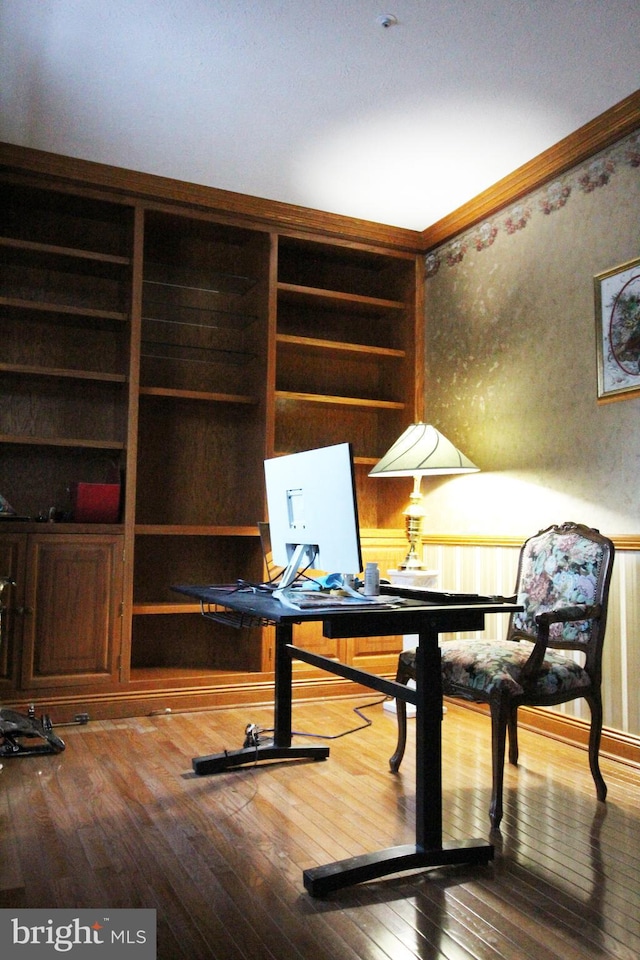 office area with wood-type flooring, built in features, and crown molding