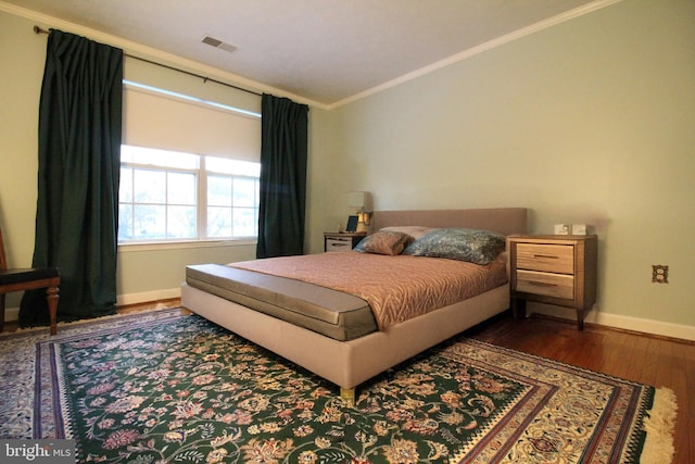 bedroom with dark wood-type flooring and ornamental molding