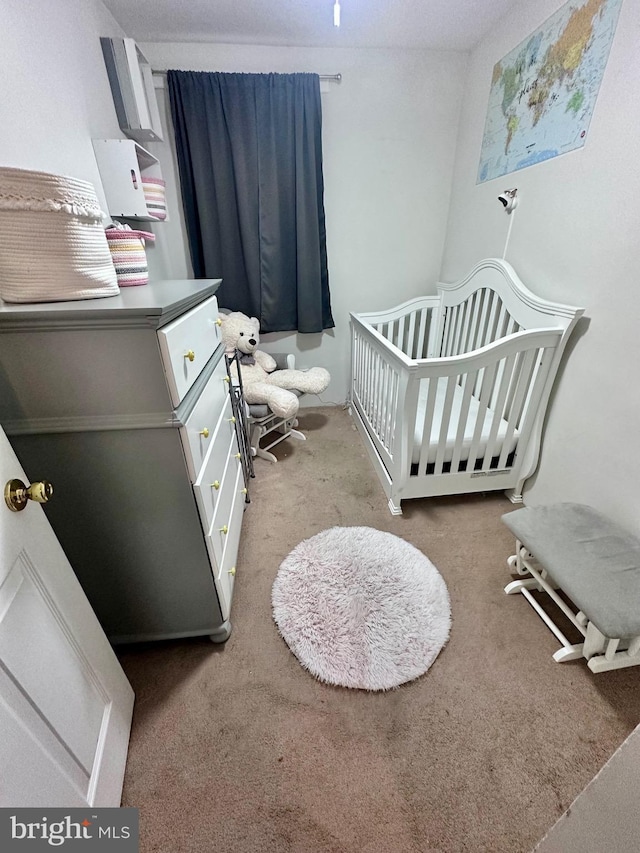 carpeted bedroom with a nursery area