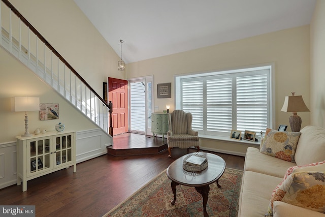 living room featuring dark wood-type flooring and high vaulted ceiling