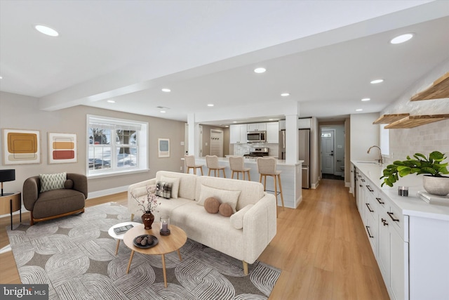 living room with sink and light hardwood / wood-style flooring