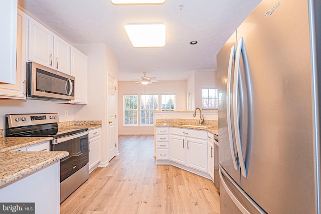 kitchen featuring sink, light wood-type flooring, white cabinetry, and appliances with stainless steel finishes