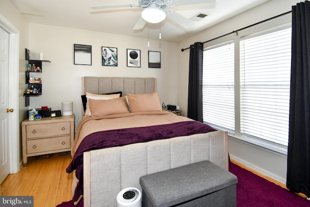 bedroom with multiple windows, ceiling fan, and light hardwood / wood-style flooring