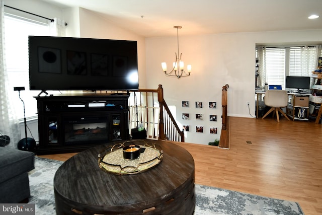 living room with hardwood / wood-style flooring and a notable chandelier