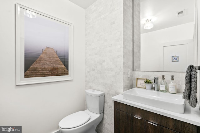 bathroom with backsplash, toilet, and vanity