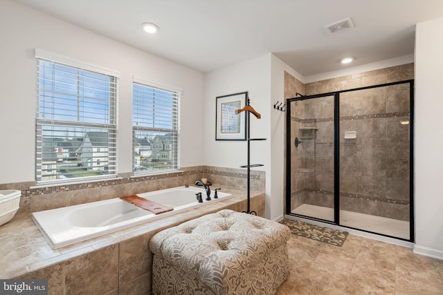 bathroom featuring separate shower and tub