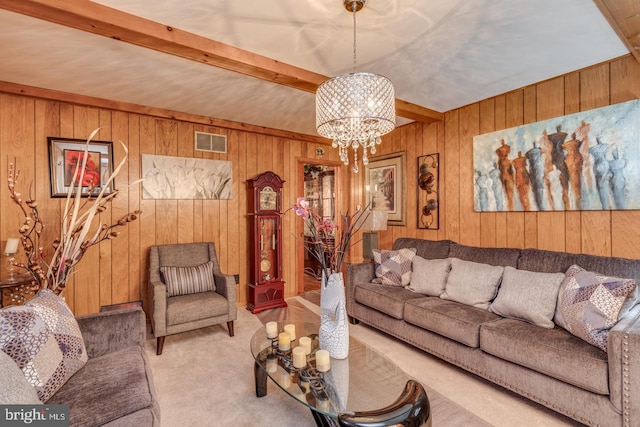 carpeted living room with beamed ceiling, a chandelier, and wood walls