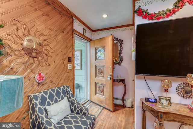 sitting room with ornamental molding, a baseboard heating unit, and hardwood / wood-style floors