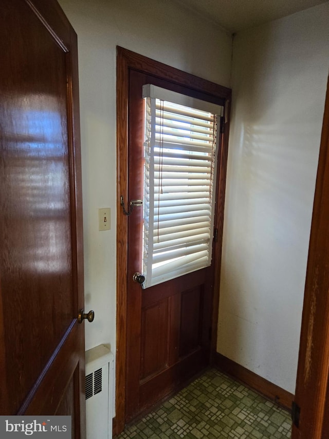 doorway featuring radiator and baseboards