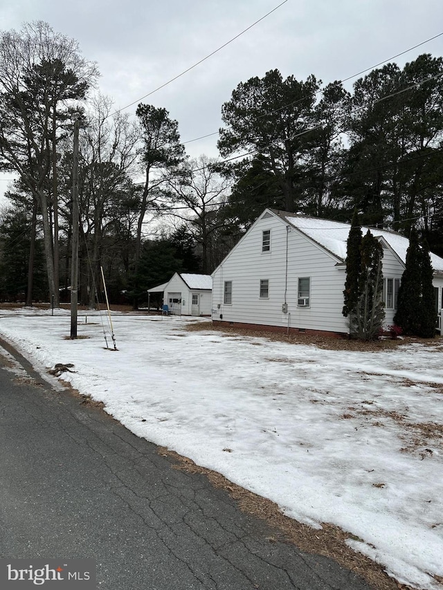 snow covered property featuring an outdoor structure