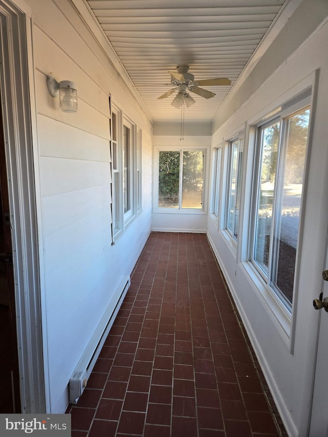 unfurnished sunroom featuring a baseboard heating unit, ceiling fan, and wooden ceiling