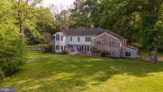 rear view of property featuring a lawn