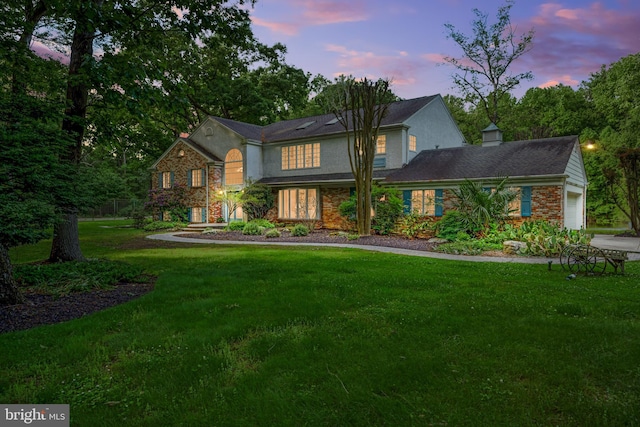 back house at dusk featuring a yard