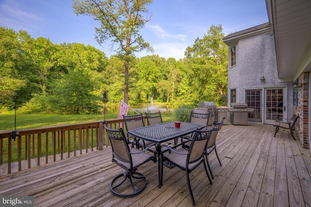 wooden terrace with a lawn and a grill