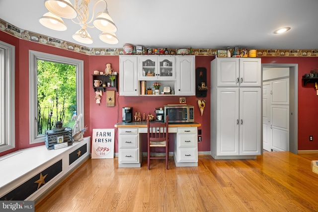 unfurnished office featuring light hardwood / wood-style flooring and a notable chandelier