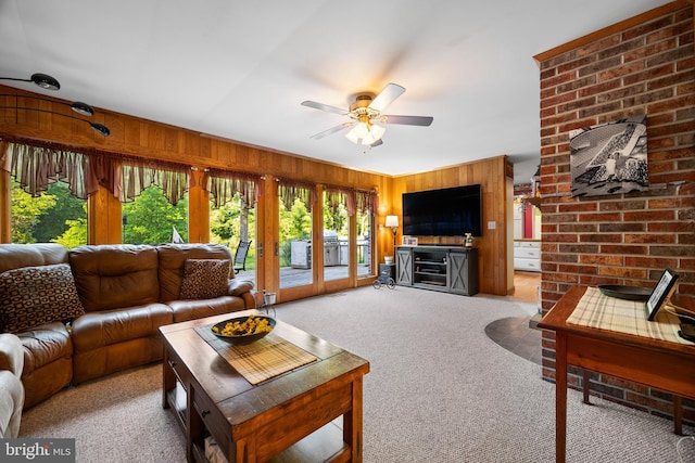 living room with carpet flooring, wooden walls, ceiling fan, and french doors