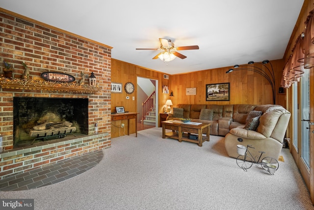 living room featuring carpet floors, a brick fireplace, wood walls, and ceiling fan