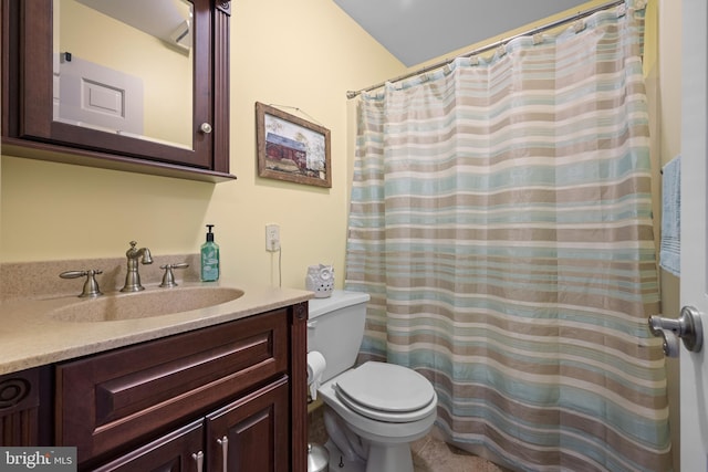 bathroom featuring vanity, toilet, and vaulted ceiling