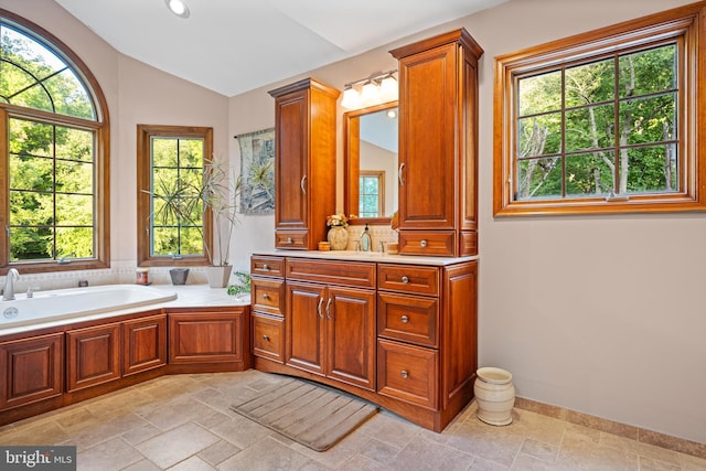 bathroom featuring a wealth of natural light, vanity, and vaulted ceiling