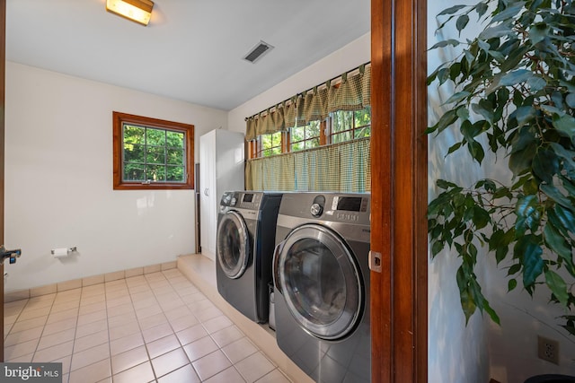 laundry room with washer and clothes dryer and light tile patterned flooring