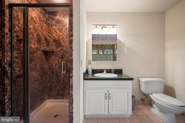 bathroom featuring an enclosed shower, vanity, toilet, and tile patterned flooring