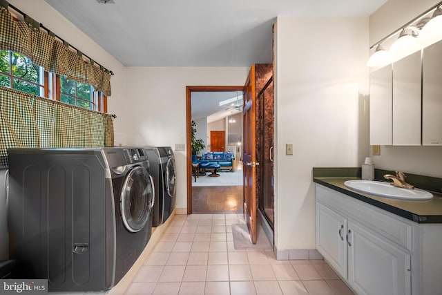 laundry area with sink, separate washer and dryer, and light tile patterned floors