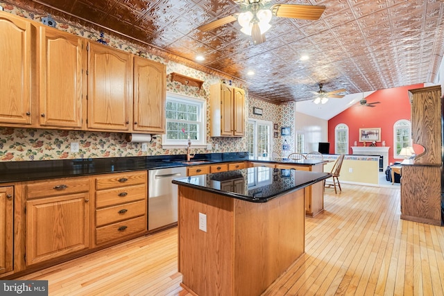 kitchen with a center island, dishwasher, vaulted ceiling, a fireplace, and an ornate ceiling