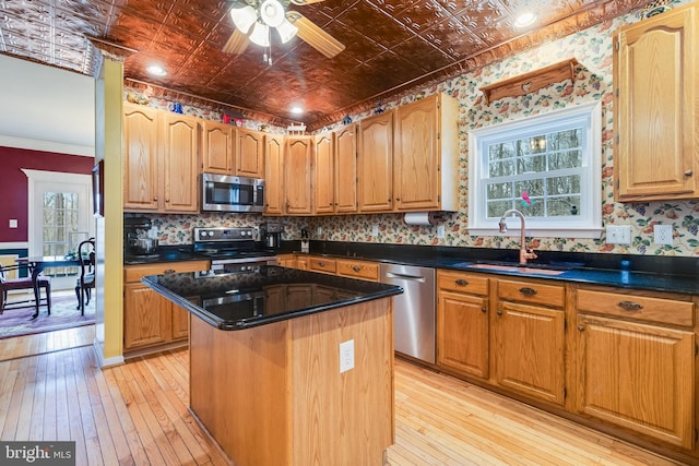 kitchen featuring a center island, appliances with stainless steel finishes, an ornate ceiling, and a sink