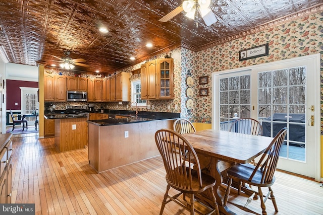 kitchen with wallpapered walls, an ornate ceiling, ceiling fan, a sink, and stainless steel appliances