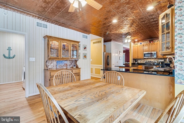 dining space with visible vents, an ornate ceiling, light wood-style floors, and ceiling fan