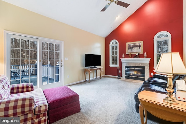 living area with ceiling fan, baseboards, a premium fireplace, carpet flooring, and high vaulted ceiling