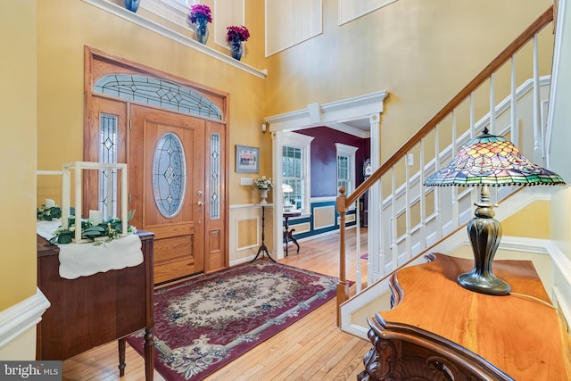 foyer with stairway, a towering ceiling, and hardwood / wood-style flooring