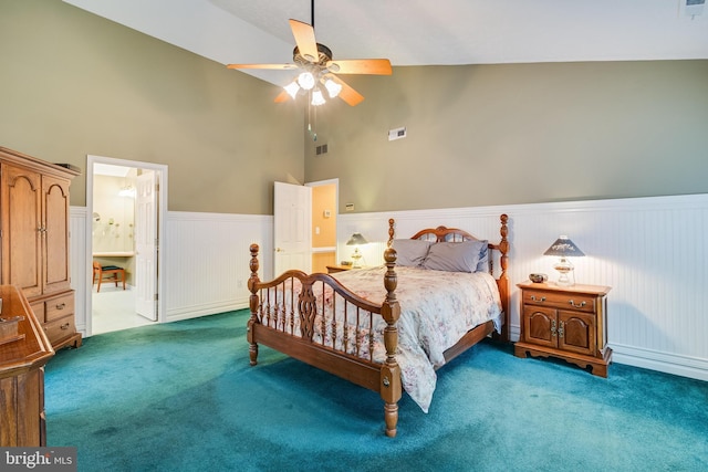 carpeted bedroom featuring ceiling fan, high vaulted ceiling, visible vents, and wainscoting