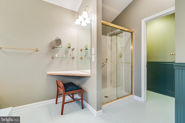 full bathroom with a wainscoted wall, baseboards, and a stall shower