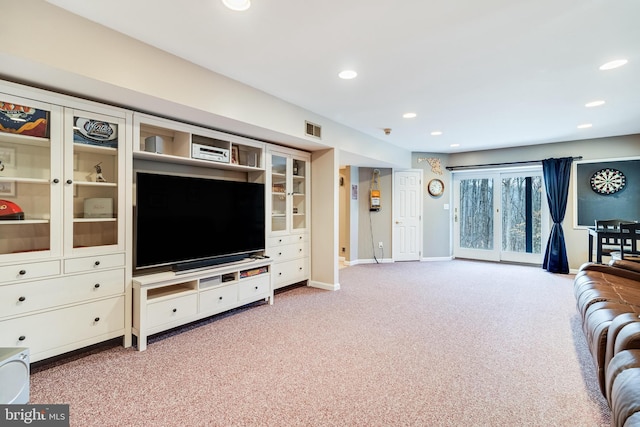 living area featuring baseboards, recessed lighting, visible vents, and light carpet