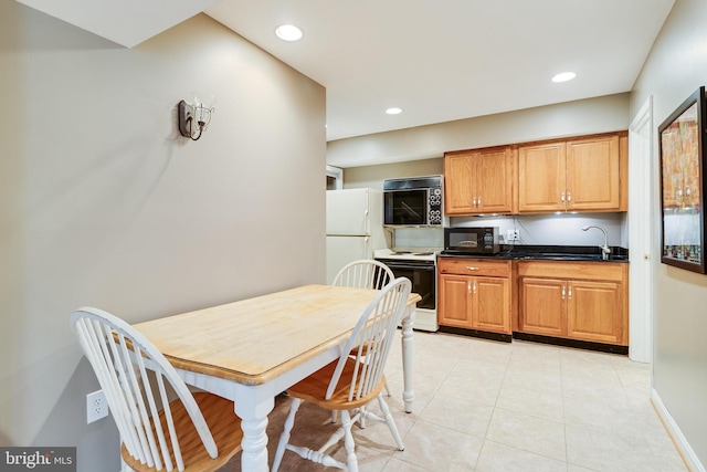 kitchen with white appliances, light tile patterned floors, recessed lighting, a sink, and dark countertops