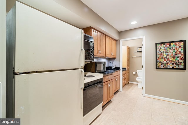 kitchen with baseboards, black microwave, freestanding refrigerator, and electric range oven