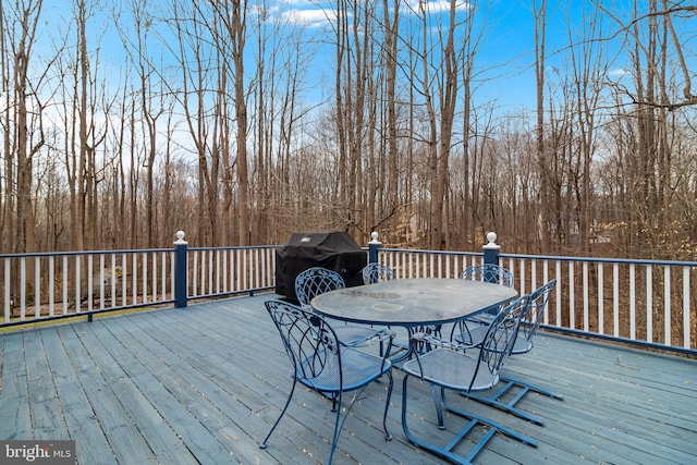 deck featuring outdoor dining space and area for grilling