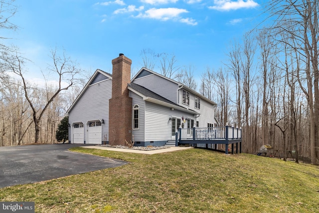 view of side of home featuring crawl space, driveway, a chimney, and a yard