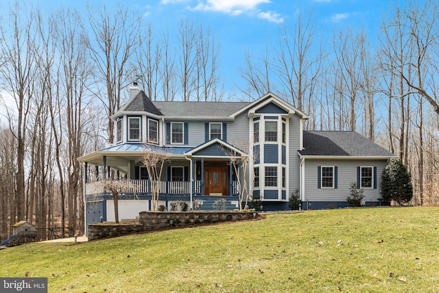 victorian home featuring covered porch, a front yard, a shingled roof, a garage, and a chimney