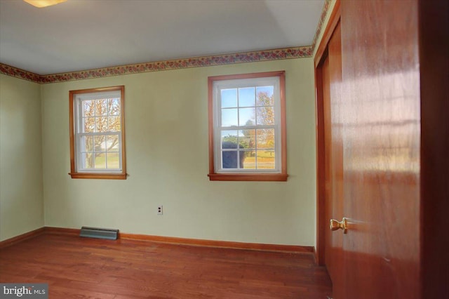 unfurnished room featuring hardwood / wood-style flooring and a healthy amount of sunlight