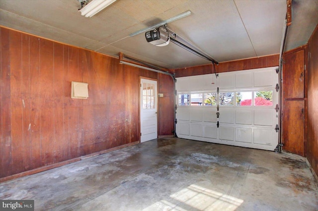 garage with a garage door opener and wooden walls