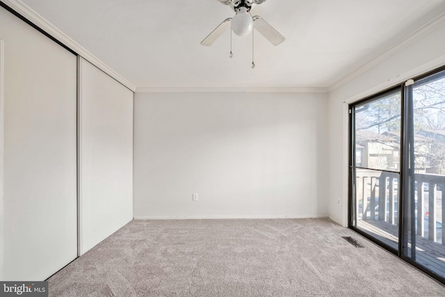 interior space featuring ornamental molding, light colored carpet, a closet, and ceiling fan