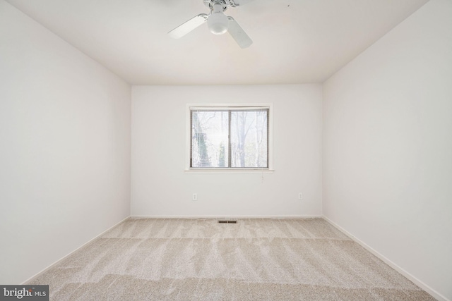 empty room featuring ceiling fan and light colored carpet