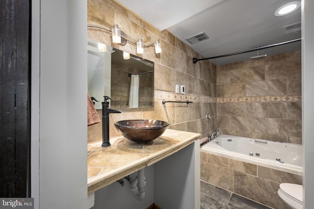 full bathroom with sink, tile walls, tasteful backsplash, shower / bath combination with curtain, and toilet